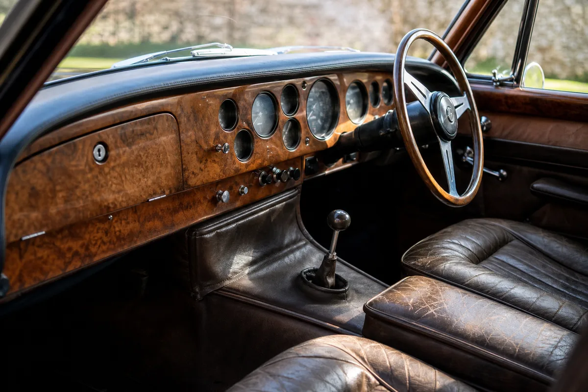 Intérieur d’une voiture anglaise de collection avec volant à droite et tableau de bord en bois